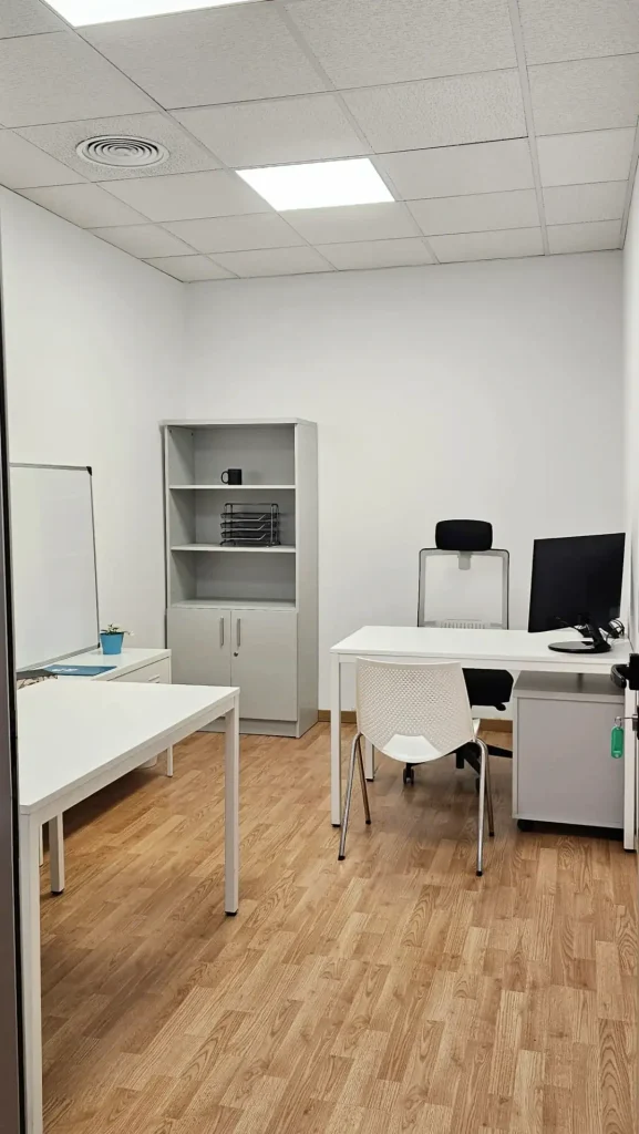 Despacho privado equipado con ordenador y estantería en centro de negocios INN Offices Aljarafe, Sevilla