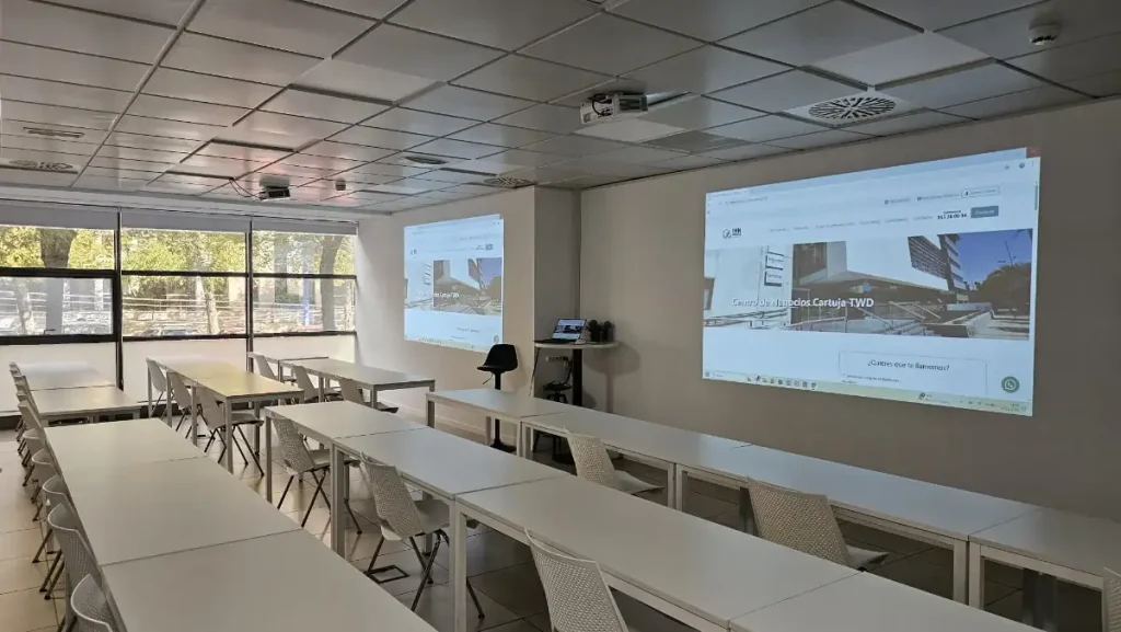 Sala de formación con proyector y mesas en centro de negocios INN Offices Cartuja TWD, Sevilla