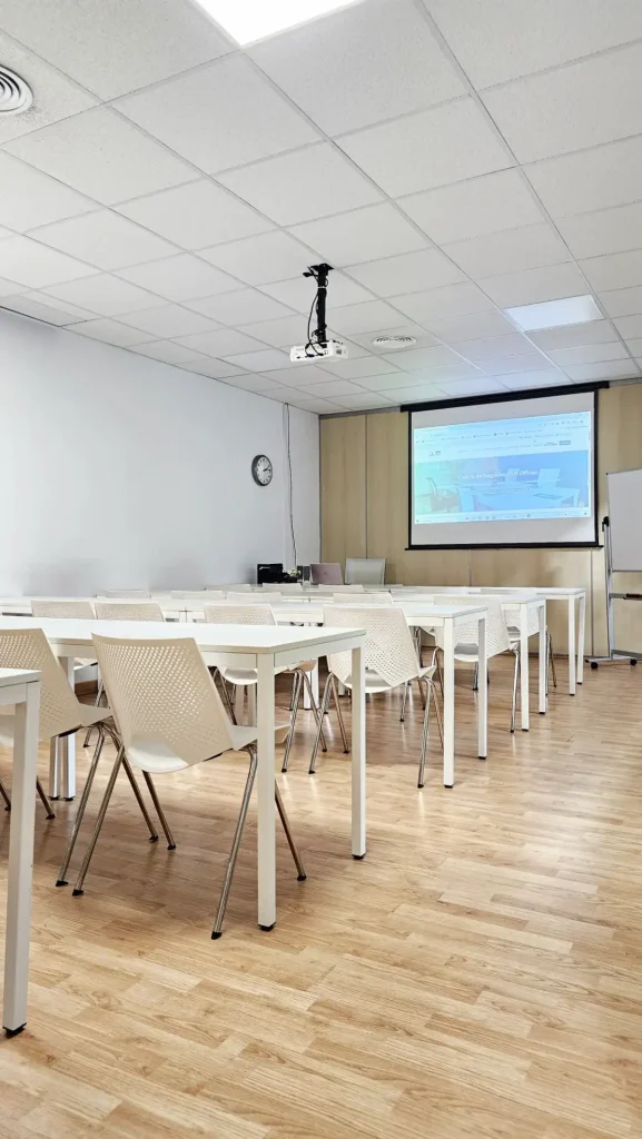 Sala de formación con proyector y sillas blancas en centro de negocios INN Offices Aljarafe, Sevilla