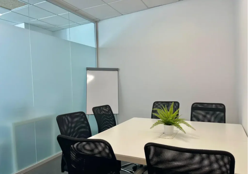 Sala de reunión con pantalla de videoconferencia en centro de negocios INN Offices Torre Aljarafe