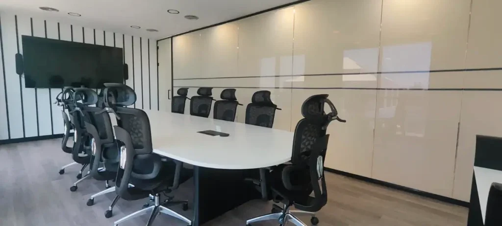Sala de reuniones con pantalla y mesa de dirección en el centro de negocios INN Offices Torneo, Sevilla